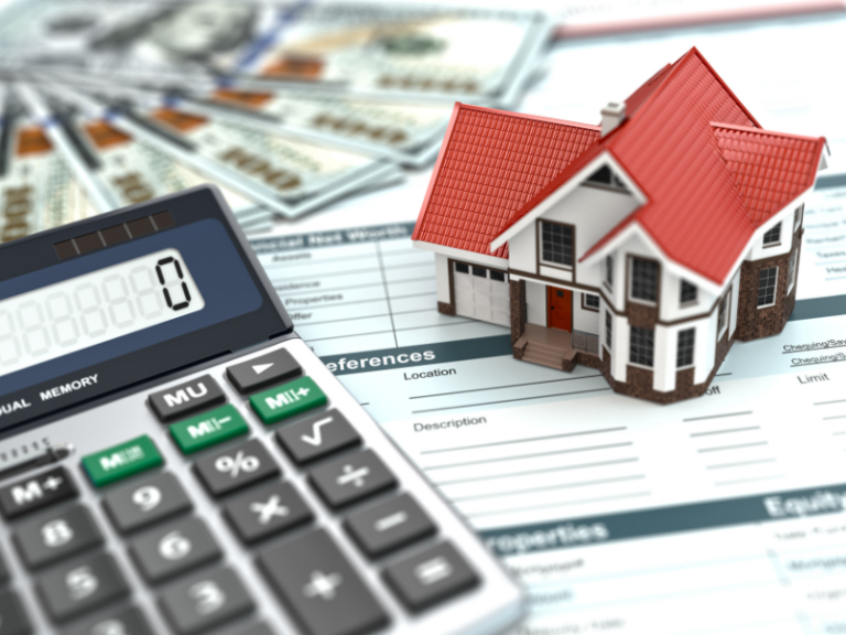 Calculator, model house with red roof, US dollar bills, and financial documents.