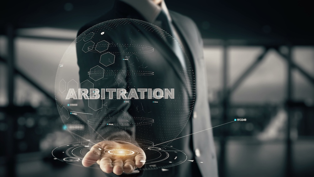 Businessman in suit holding holographic globe with word "ARBITRATION" and digital data.