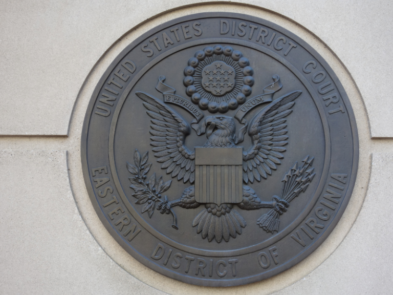 Bronze seal of the United States District Court for the Eastern District of Virginia mounted on a beige stone wall.