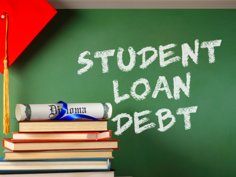 Stack of books with diploma and red graduation cap beside chalkboard displaying "Student Loan Debt" text.