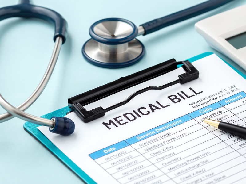 Medical bill on clipboard with pen and stethoscope on light blue background.