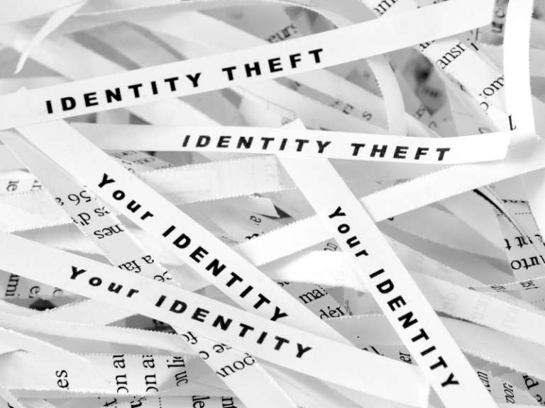 Shredded white paper strips with the words "IDENTITY THEFT" and "Your IDENTITY" in black text.
