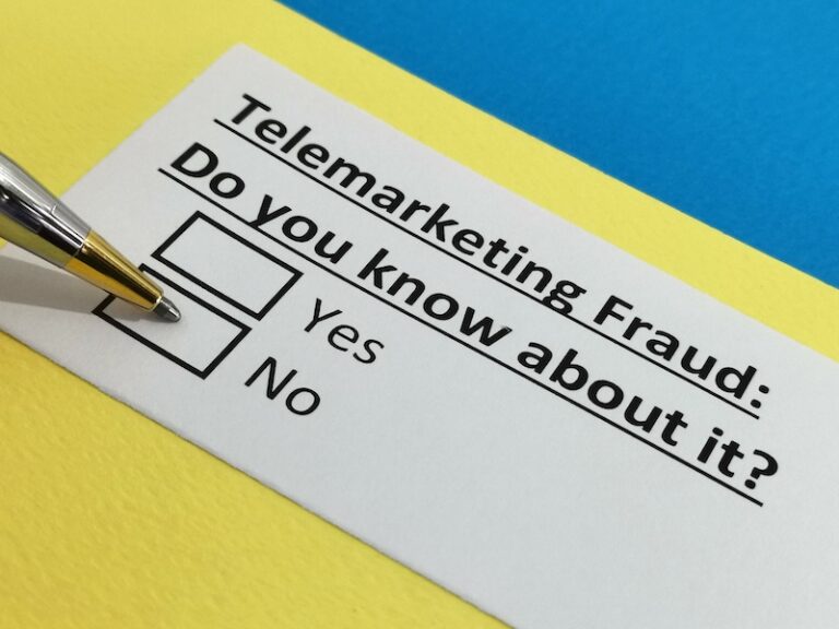 Pen pointing at "No" option on telemarketing fraud awareness questionnaire on yellow and blue background.
