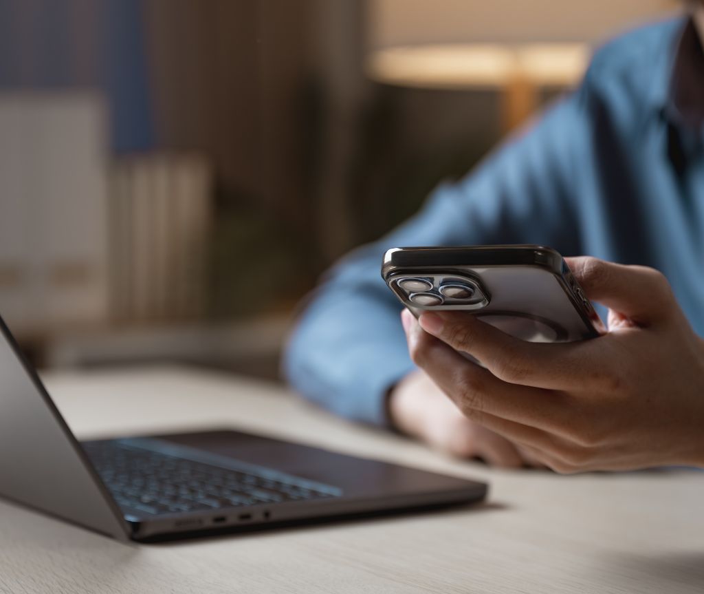 man looking at phone and laptop