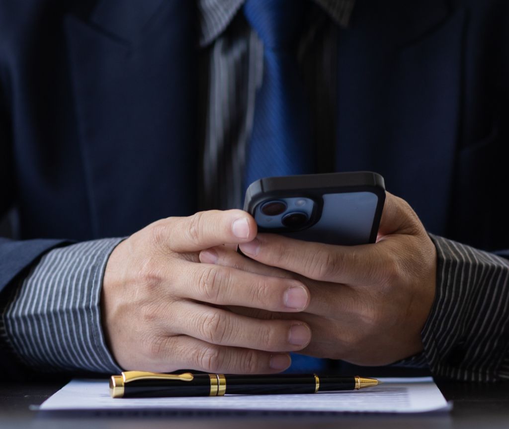 closeup of man's hands as he looks at phone